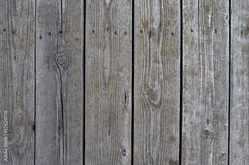 Background of old boards nailed down. Weathered boards form a vertical pattern. Old wooden wall. The wall is made of old natural wood.