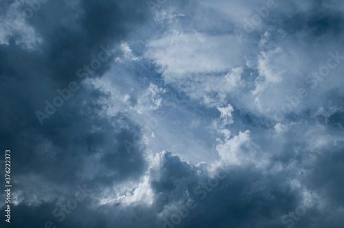 Dramatic dark blue sky with heavy clouds background.