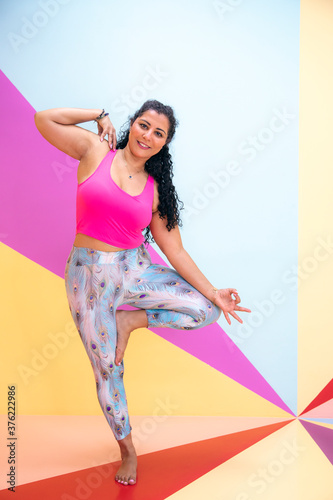 young woman in a yoga pose in a colorful room photo