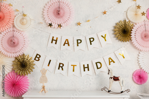 Birthday decorations - gifts, toys, balloons, garland and figure for little baby party on a white wall background. photo