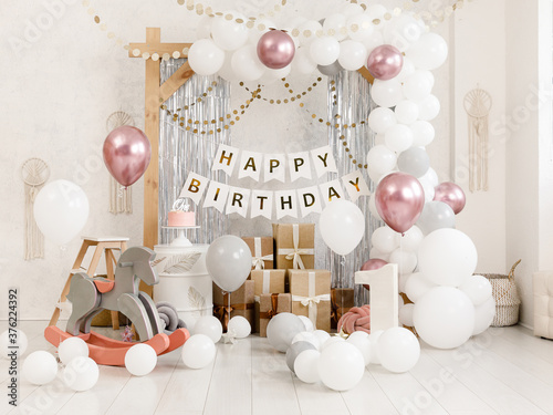 Birthday decorations - gifts, toys, balloons, garland and figure for little baby party on a white wall background.