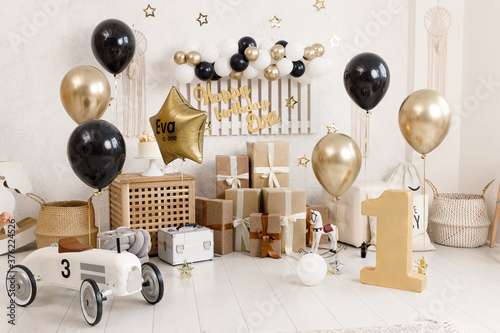 Birthday decorations - gifts, toys, balloons, garland and figure for little baby party on a white wall background. photo