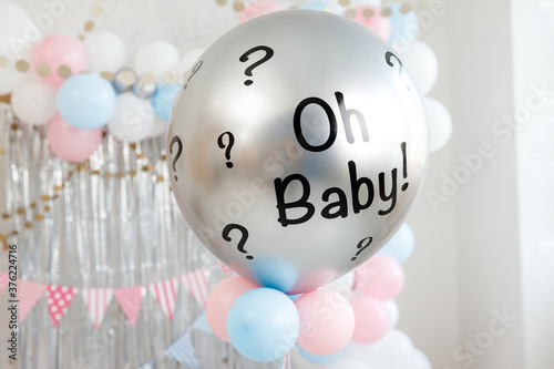 Gender party decorations - gifts, toys, balloons, garland and figure for little baby party on a white wall background. Oh baby! photo