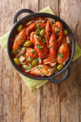 Chicken Marengo is a French dish is served with a crawfish closeup in the pan on the table. Vertical top view from above photo