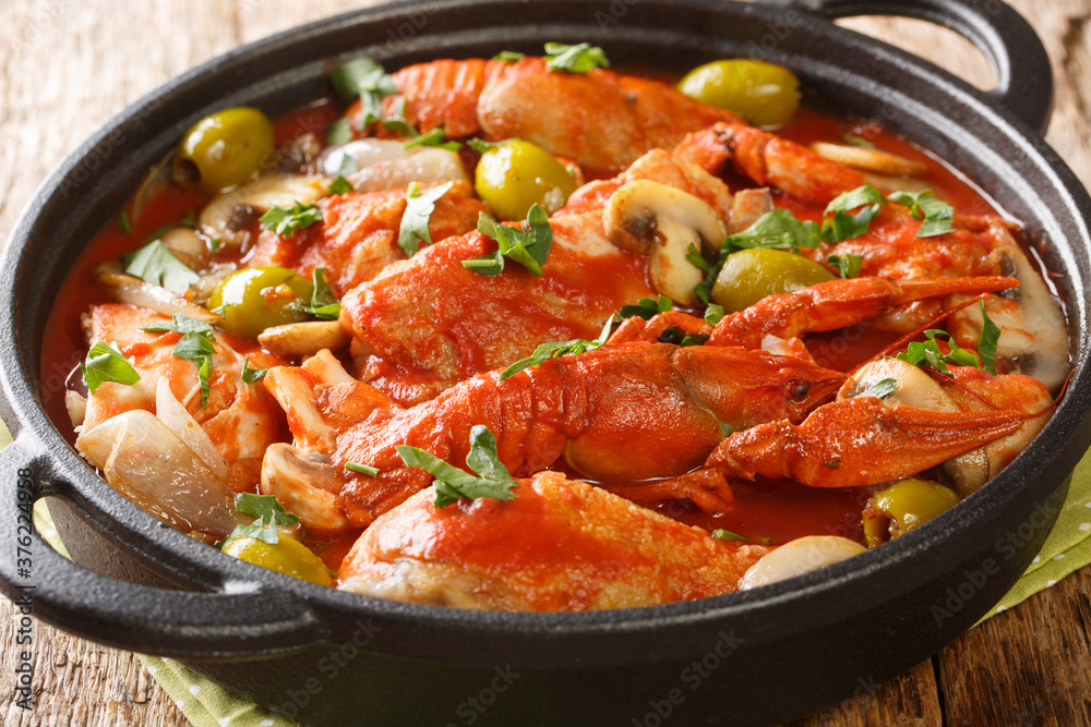 Chicken marengo is a hearty, but bright, simmered dish, full of mushrooms, crayfish, tomatoes, garlic and white wine close-up on the table. Horizonta Chicken marengo is a hearty, but bright, simmered dish, full of mushrooms, crayfish, tomatoes, garlic and white wine close-up on the table. Horizonta