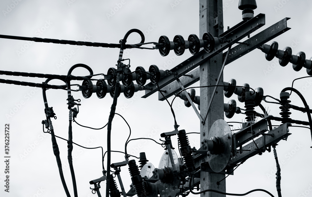 Black and white scene of three-phase electric power for transfer power by electrical grids. Electric power for support manufacturing industry. High voltage electric poles and wire lines. Black and white scene of three-phase electric power for transfer power by electrical grids. Electric power for support manufacturing industry. High voltage electric poles and wire lines.