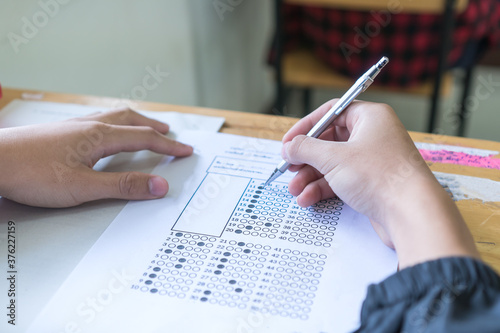 Evaluation or measurement concept. Student testing in exercise taking fill in exam at school or university in test room, writing document exams paper at campus classroom, education back to school idea