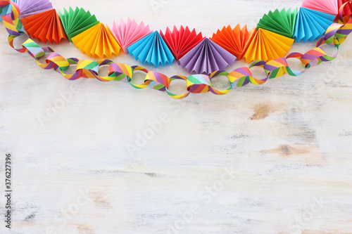 Paper colorful chain garland over white wooden background. Traditional jewish sukkot holiday decoration © tomertu