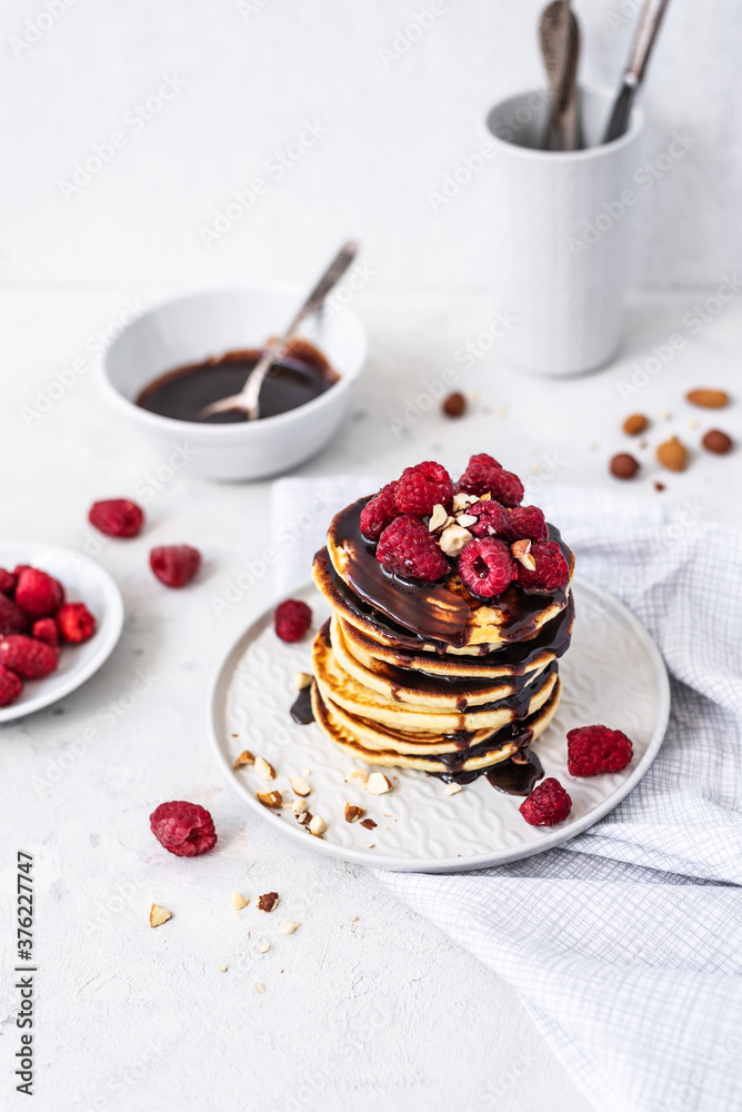 Tasty Pancakes. Stack of pancakes topped with chocolate and raspberry. Breakfast Tasty Pancakes. Stack of pancakes topped with chocolate and raspberry. Breakfast