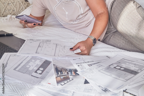 Woman interior designer with interior plans for a new project and notebook