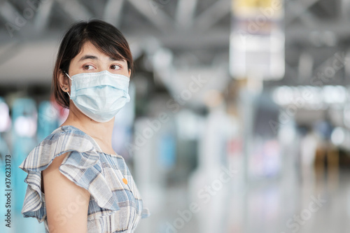 Young adult female wearing face mask in airport terminal, protection Coronavirus disease infection, Asian woman traveler ready to travel. New Normal and travel under COVID-19 concept