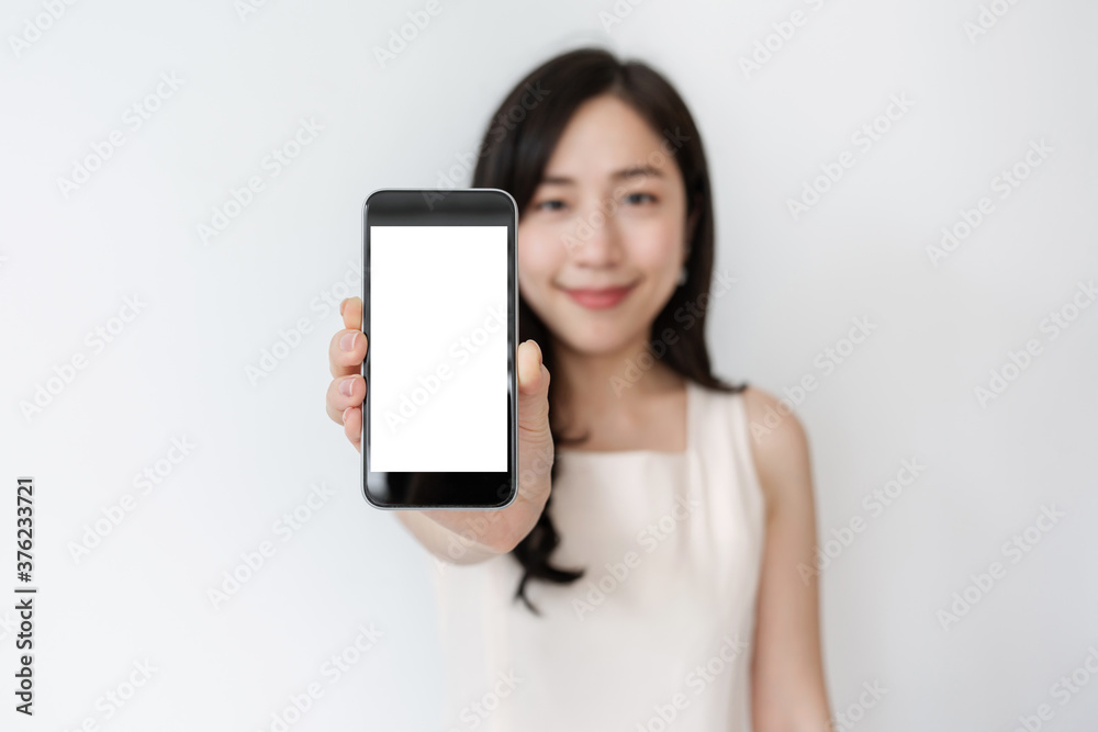 Asian woman showing mobile smart phone with smiling face, empty white screen