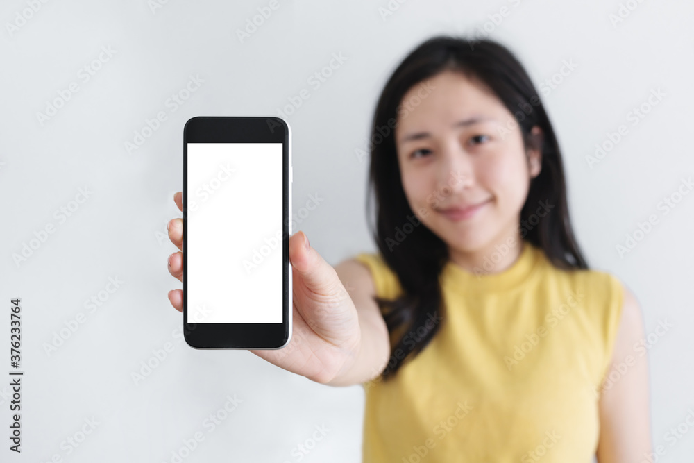 Asian woman showing mobile smart phone with smiling face, empty white screen