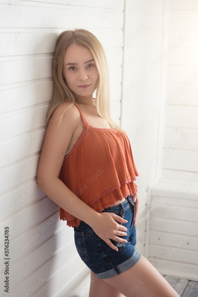 Fashion young blonde woman in red blouse over white wooden background Fashion young blonde woman in red blouse over white wooden background