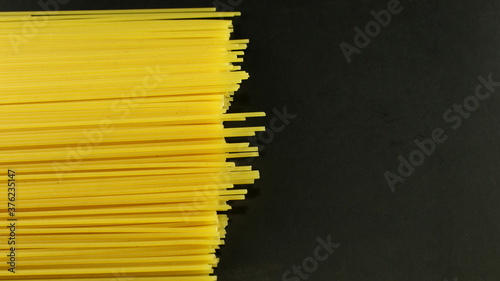 Yellow long spaghetti on black background