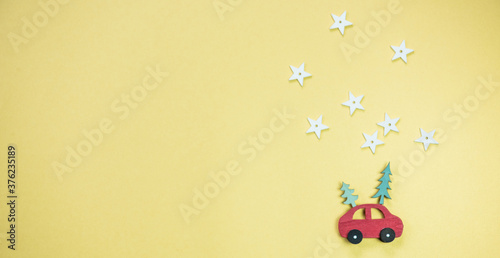 Sipelzeugauto mit Sternen und Schneeflocken auf gelben Untergrund, weihnachtlich gestaltet 