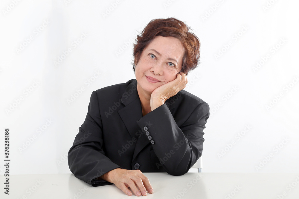 Elderly asian Chinese female on white background wearing black suit thinking hand on cheek look at camera Elderly asian Chinese female on white background wearing black suit thinking hand on cheek look at camera