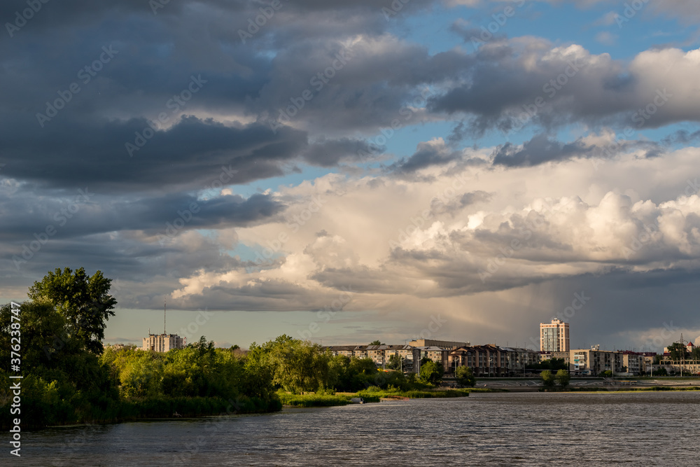 Fototapeta premium Beautiful clouds over the river and city