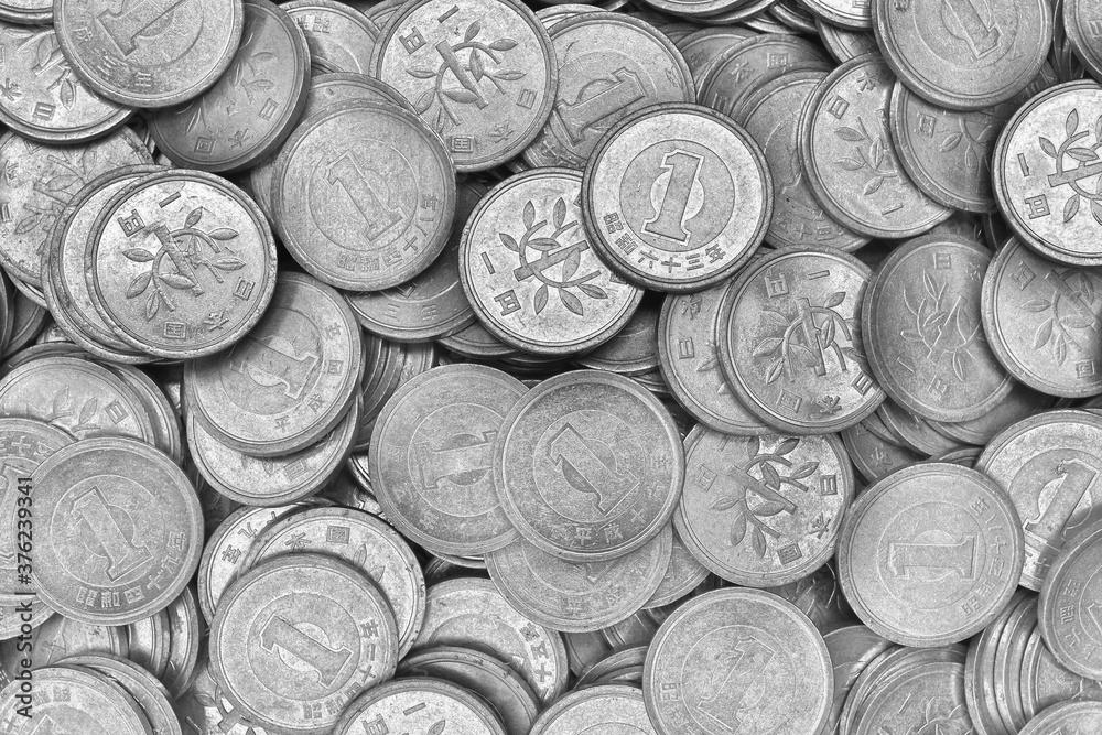 Surface of Japanese 1 one yen coins in close-up. Black and white light background or wallpaper. The backdrop on the theme of finance, the central bank or the economy of Japan. Top view. Macro Surface of Japanese 1 one yen coins in close-up. Black and white light background or wallpaper. The backdrop on the theme of finance, the central bank or the economy of Japan. Top view. Macro