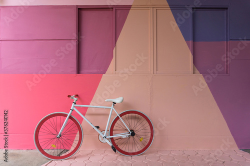 Bicycle with colorful (purple, blue pink and beige) wall as background