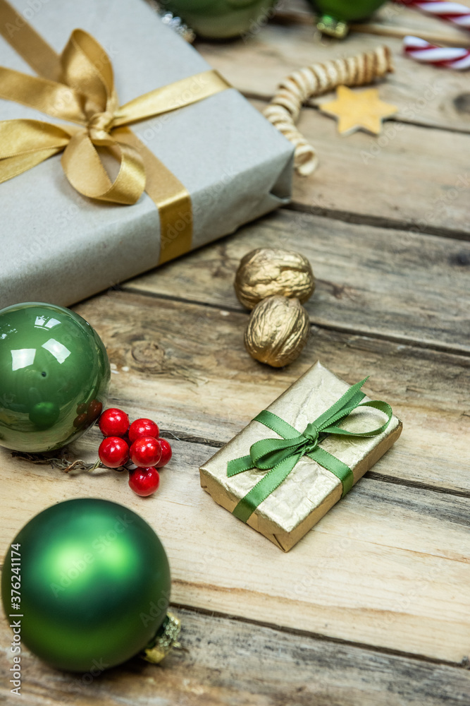 Fototapeta premium Sortiment für Weihnachten, Kugeln, Geschenk, Stern, Schnee in gold, grün und gelb auf rustikalem Hintergrund