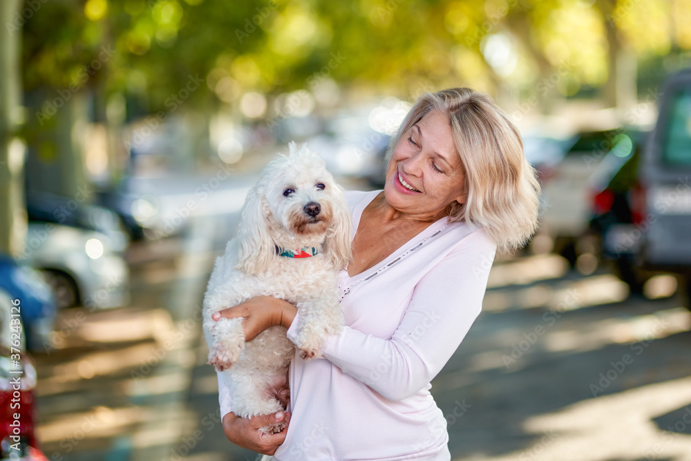 Elderly woman walking with a dog outdoors Elderly woman walking with a dog outdoors