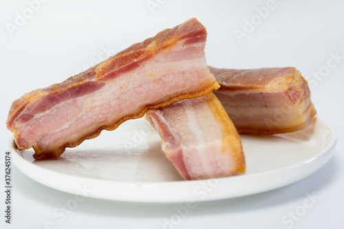 Tiras gruesas de bacon curado para freír en aceite y preparar torreznos photo