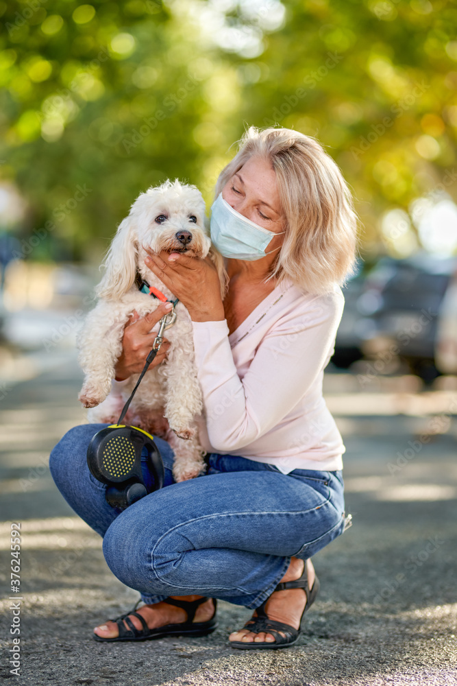 Portrait elderly woman with a dog outdoors an antivirus mask Portrait elderly woman with a dog outdoors an antivirus mask