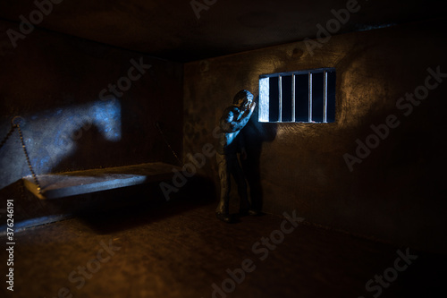 Jail or prison cell. Man in prison man behind bars concept. Old dirty grunge prison miniature. Dark prison interior creative decoration. Selective focus