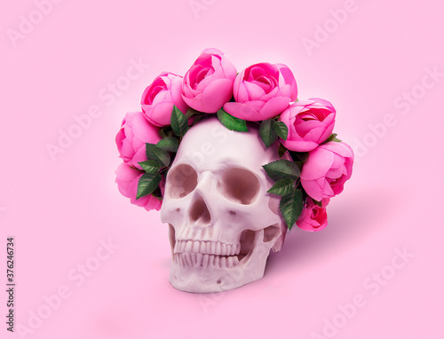 Skull with a wreath of roses on a pink background