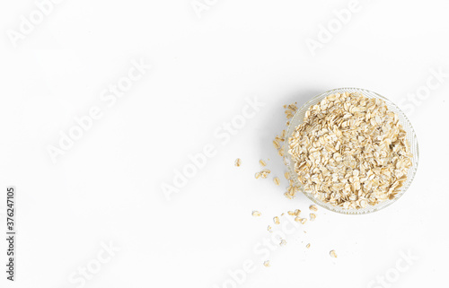 Wallpaper Mural Dry oatmeal in a bowl and scattered nearby, isolated on a white background with copy space. View from above. The concept of healthy food, diet, healthy breakfast. Torontodigital.ca