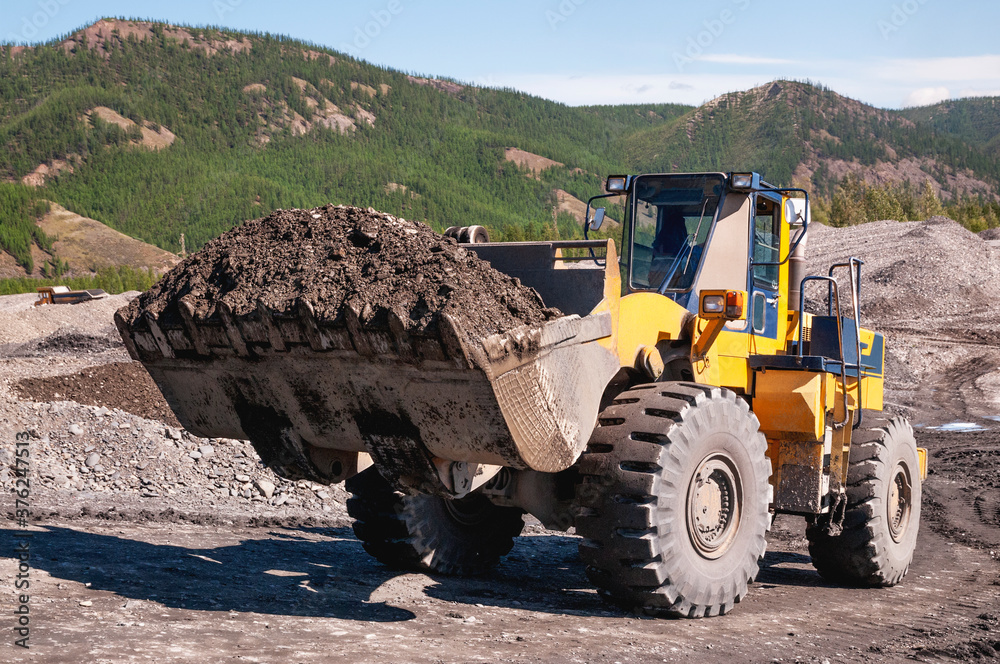 Frontend loader in the mode of transporting mountain soil. Earthworks