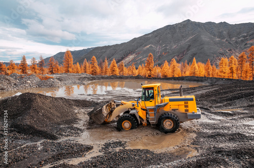 Excavation work in a mountainous wooded area. Front loader at work.