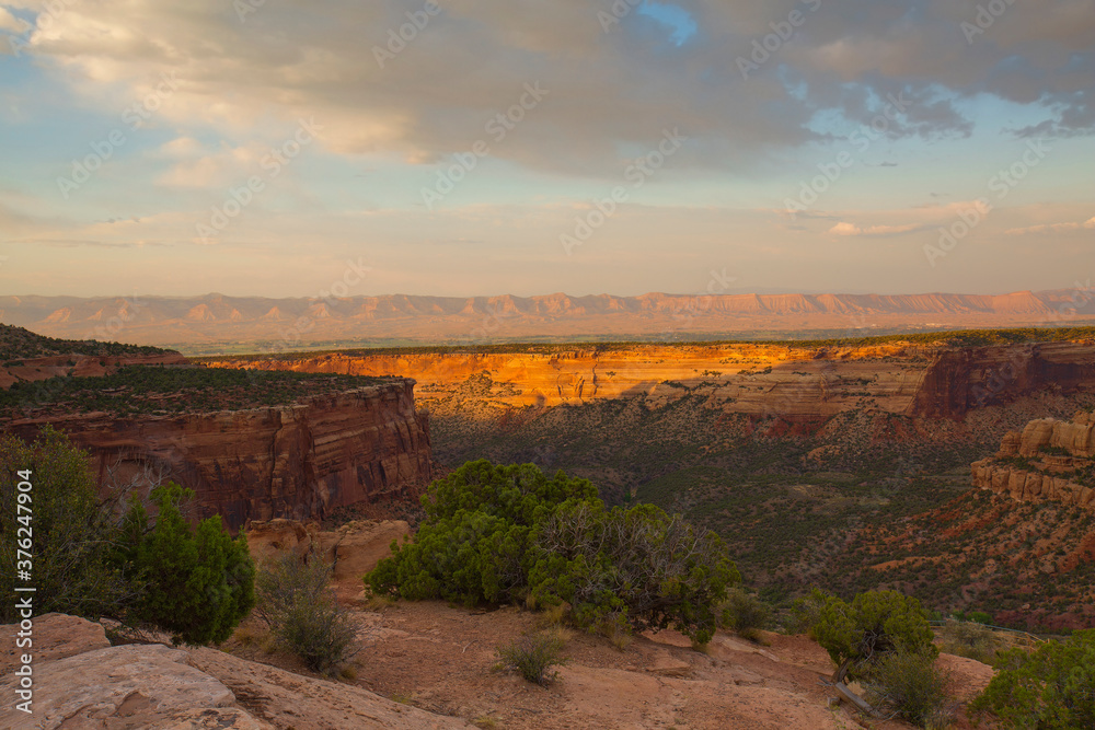 Golden sunset light falls on rock formations at Colorado National Monument
