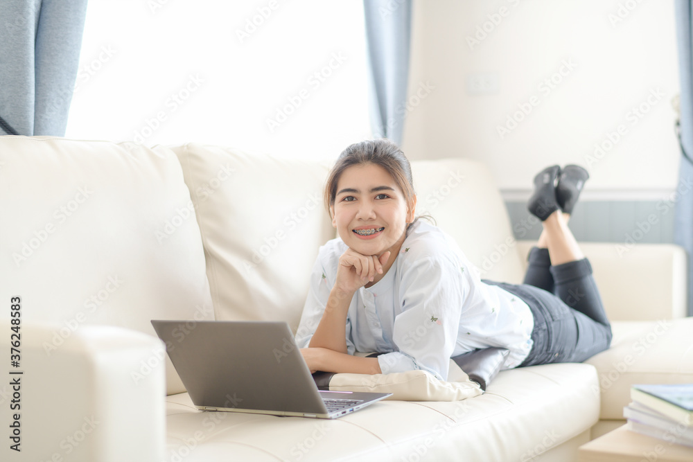 Young women working on laptops looking online And relax comfortably in the living room in the house Young women working on laptops looking online And relax comfortably in the living room in the house