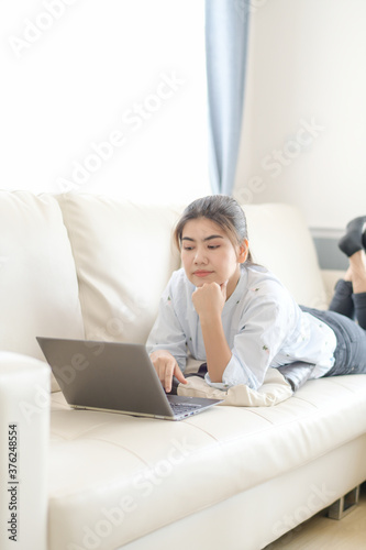 Young women working on laptops looking online And relax comfortably in the living room in the house