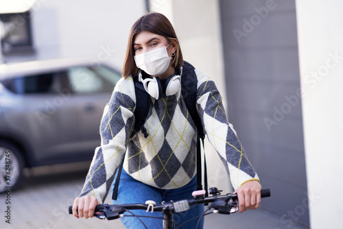 Teenager going to school by boke with a mask on