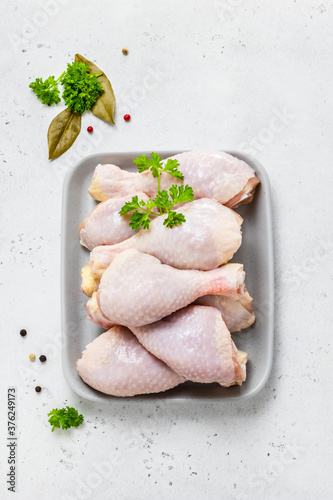 Fresh chicken legs with spices, mustrad, parsley. Top view, copy space.