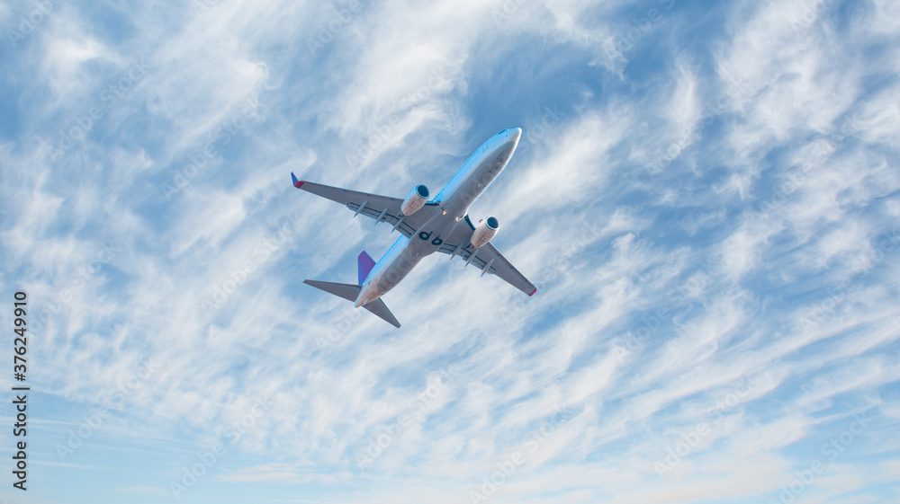 Fototapeta premium White passenger airplane in the stormy clouds - Travel by air transport