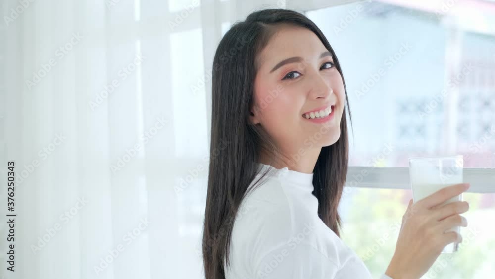 Attractive Asian woman drinking milk and smiling at home close up face.healthy life style. Attractive Asian woman drinking milk and smiling at home close up face.healthy life style.