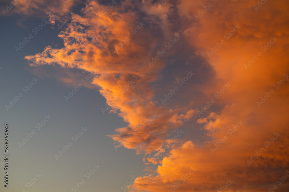 Clouds in the evening - yellow and orange sunset light lits cloud. beautiful abstarct nature with orange and blue colors. 