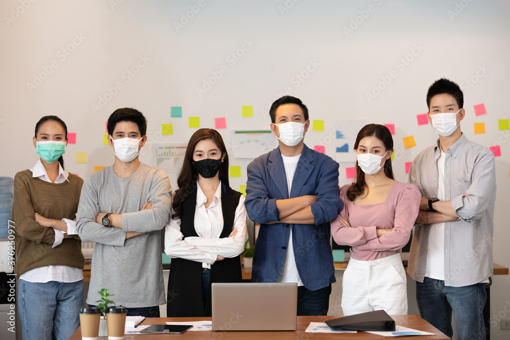 Group of Happy Asian business men leader standing wearing mask smile cross arm confidence with Business team at Co-Working space or modern office Due Covid-19 flu pandemic Group of Happy Asian business men leader standing wearing mask smile cross arm confidence with Business team at Co-Working space or modern office Due Covid-19 flu pandemic