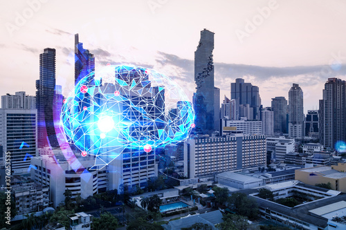 Glowing human brain hologram, aerial panoramic cityscape of Bangkok at sunset. The center of business education in Asia. Double exposure.