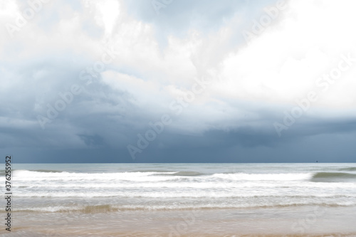 Storm clouds over the sea.The waves hit to the beach before rainy on seascape background.Bad weather for outdoor travel.