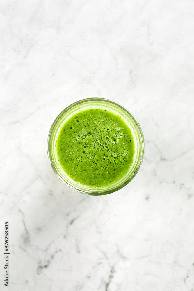 Green smoothie in glass on marble table. Top view Green smoothie in glass on marble table. Top view