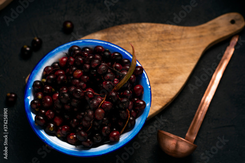 vista cenital de FRUTA DE COROZO EN UN plato azul Y UN CUCHARON  SOBRE UNA TABLA DE MADERA  Y UN FONDO DE MADERA photo