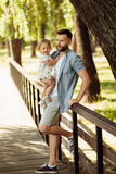 Loving father with adorable daughter at the park, caring parent hold cute toddler in arms, smiling, enjoy time together, fatherhood and childhood concept