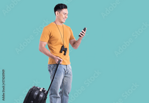 Asian man wearing casual shirt and using mobile phone while traveling