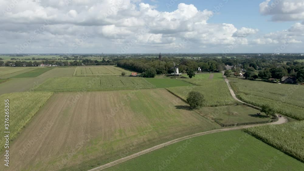 Wide jib down of traditional windmill surrounded by green meadows Wide jib down of traditional windmill surrounded by green meadows