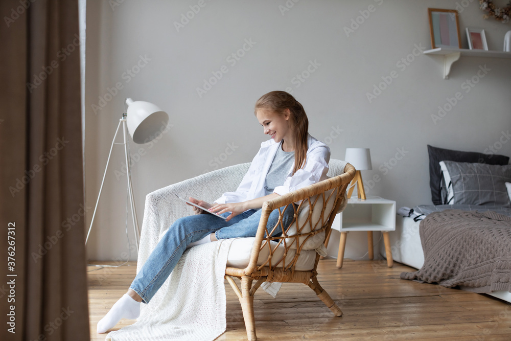 Smiling casual young woman using digital tablet at home. Videochat. Smiling casual young woman using digital tablet at home. Videochat.